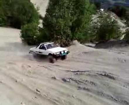 6" lifted subaru brat with 29" superswampers driving in the sands.