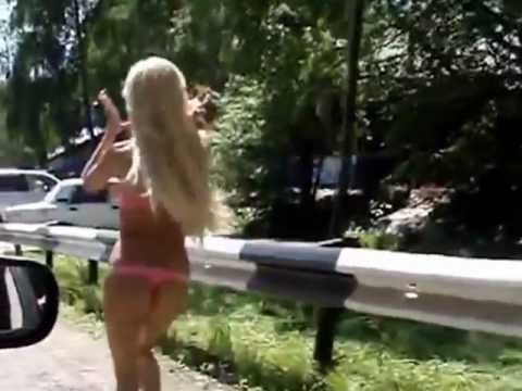 Возле желтого авто посреди дороги в эротической одежде блонда