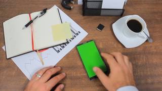 Businessman Using A Modern Smartphone With Green Screen At His Desk - Free Use