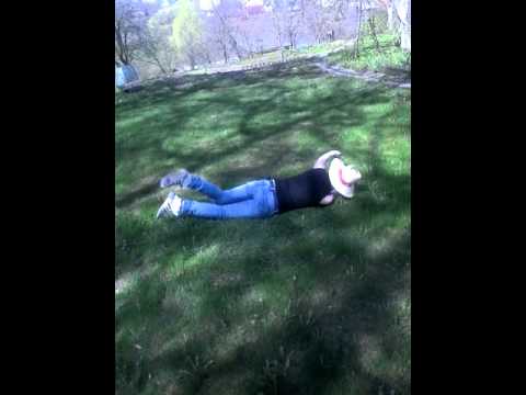 Голенькая девчонка валяется на траве и дрочит киску