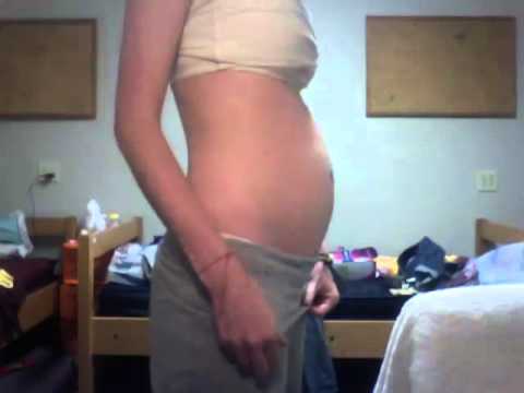 Girl plays with bloated belly after