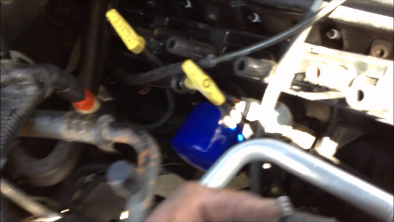 Un mecánico repara el motor de un coche en un taller 