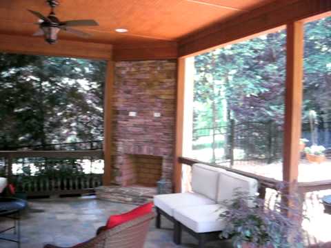 Stone outdoor fireplace integrated in covered raised patio ...
