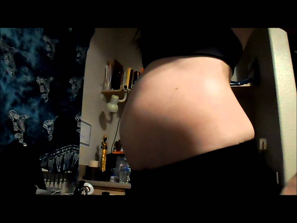 Girl plays with bloated belly after