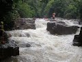 Slim River Water Rafting - Red raft going down Broken Nose Waterfall