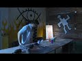 Painter snorts paint and sprays onto canvas through his eye