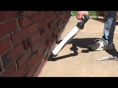Crack sealing a concrete pad where it meets the wall