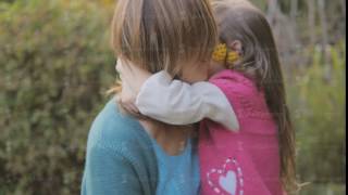 Mom And Daughter In Nature Laugh And Kiss