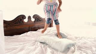 Little Girl Jumping On The Bed At Home