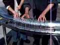 Two people playing hydraulophone (water pipe organ flute)