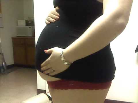 Girl plays with bloated belly after