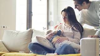 Breastfeeding Baby. Young Parents Look At Their Newborn Child And Kissing