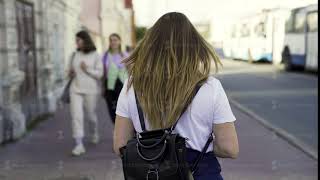 Rear View Of A Young Girl In An Urban Street In The Summertime. Media. Woman In White Shirt With
