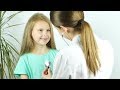A Female Doctor Hearing Heartbeat of Cute Young Girl. Review of a Child in a Pediatrician | Stock