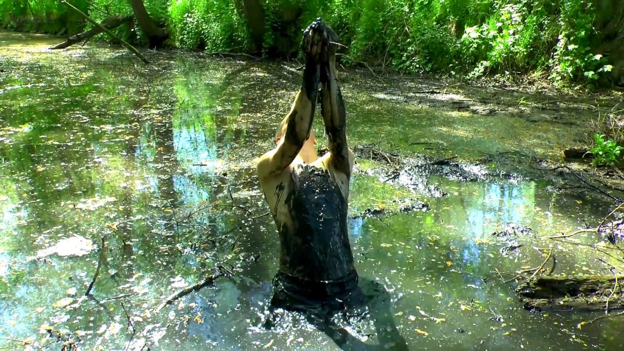 Nude girl in pool of mud