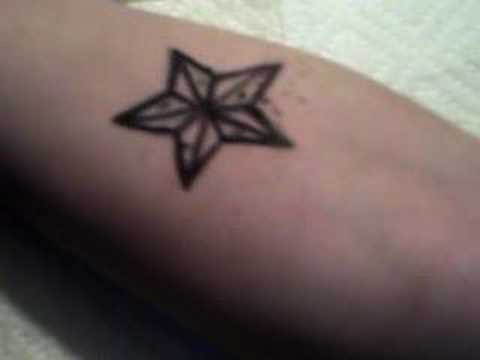 tattooing a black & blue nautical star.