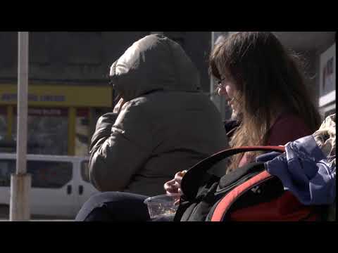 A student girl is eating fastfood salad with a roll while waiting for a bus Free HD video footage