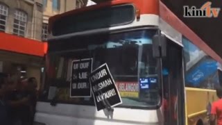 Passing bus plastered with anti-Najib posters