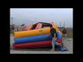 rolling up an 18' inflatable slide from Bounce About Party Rentals LLC