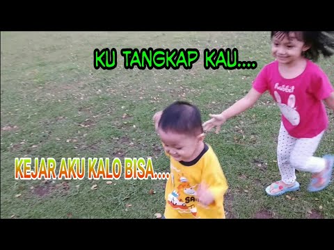 Anak kecil imut dan lucu bermain dan berlari di Padang rumput