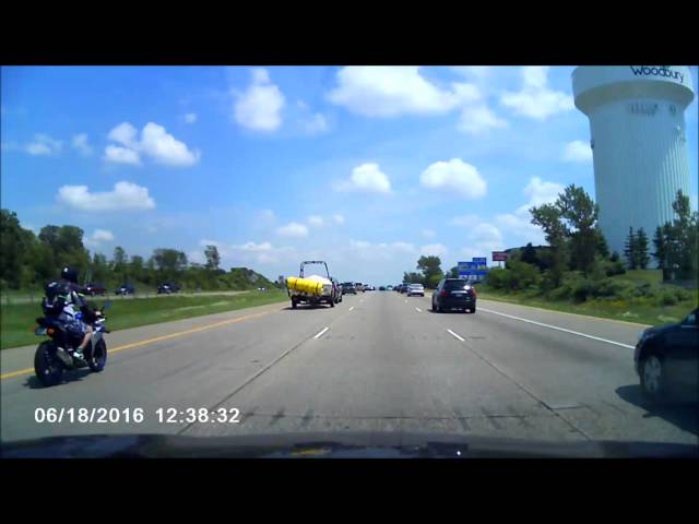 Motorcyclist Wipes Out After Truck Drops Giant Tube Onto Highway - Video
