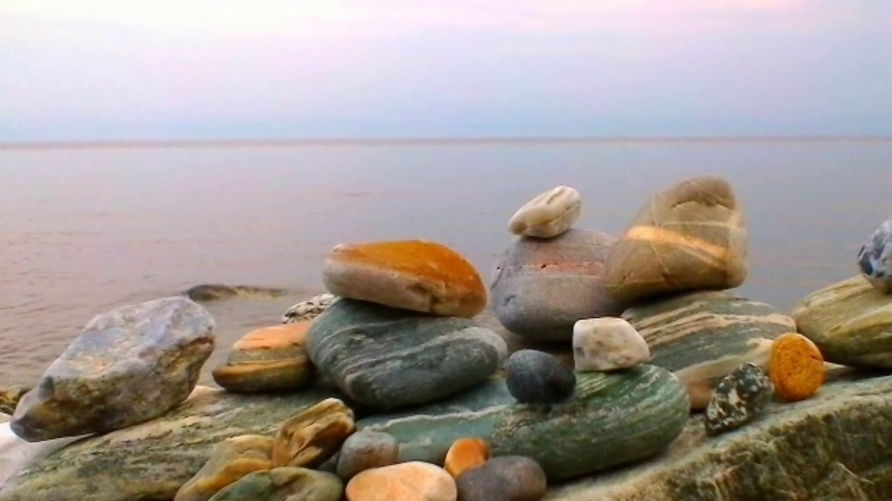Обнаженная фигурка среди прибрежных камней
