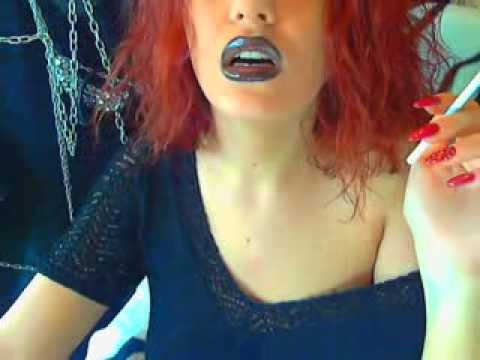 beautiful goddess with red nails and heavy makeup smokes cigarette