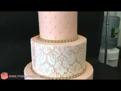 This 4 tier wedding cake is covered in blush pink fondant with white damask