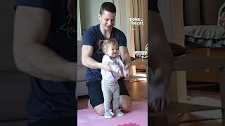 Toddler Girl Does Stretching Exercises At Home With Dads Help
