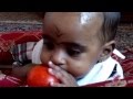 Baby Khaula struggles to bite a tomato
