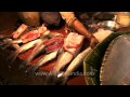 Fish seller puts incense sticks in fish basket after worshipping - Kolkata