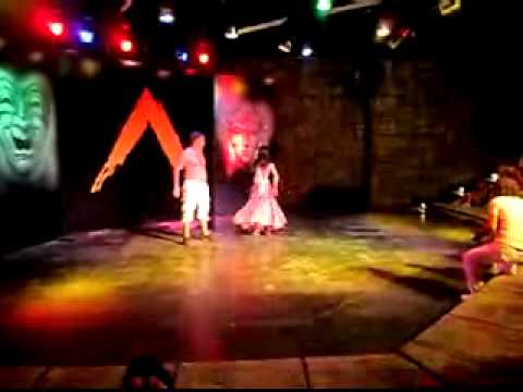 Turkish professional belly dancing showing a woman how to do it.