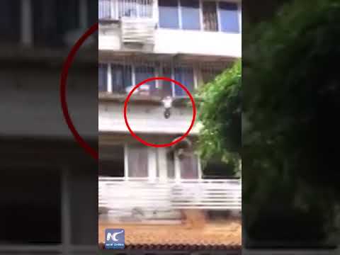 Boy hanging on window railings rescued by passers-by