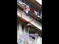 Boy hanging on window railings rescued by passers-by