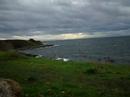 rich green grass, grey skies, and streams of light