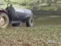 farmer unclogs fertilizer tank