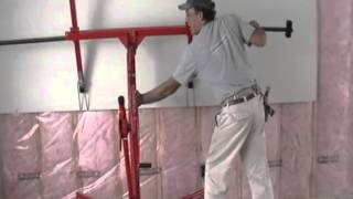 Installing drywall on upper walls with lift by Laurier Desormeaux
