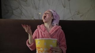 Woman Watching a Late Night Movie at TV, Eating Popcorn. Bathrobe, Facial Mask | Stock Footage -