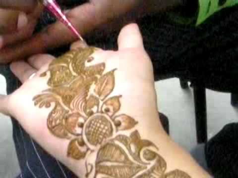  applying the henna design by washing with rose water or mustard oil