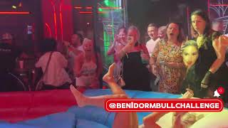 Blonde Girl In White Clothes Riding On A Mechanical Bull In Benidorm 4K