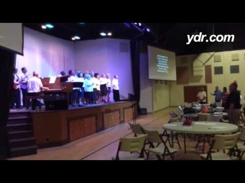 Singing during Prayer for York by York County Gospel Choir get hands up in worship with people from