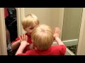 funny baby talking to himself in the mirror