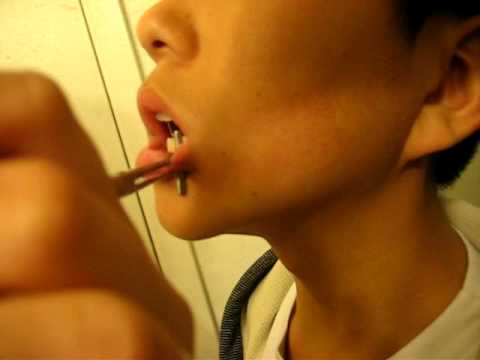 Funny asian kid getting his lip pierced