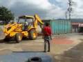 Shipping Containers in Costa Rica being unloaded with a Backhoe