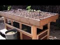 Aquaponics two-tiered back yard gardening and fish farming system made of wood.