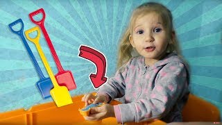 Play with sand molds and toy shovels on indoor colorful sandpit table