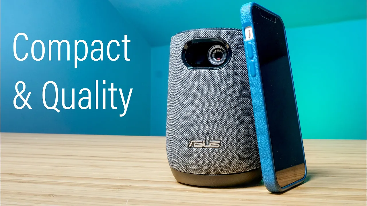 ASUS ZenBeam Latte L1 on a table next to a cellphones