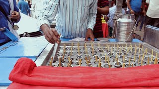 A man selling kulfi on his stall to his customers on old delhi market