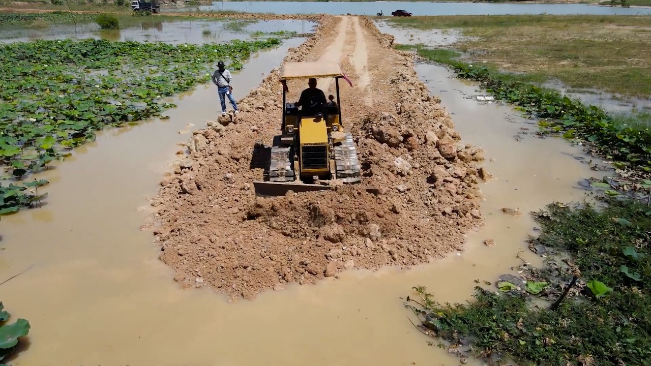 Processing Landfill Up The Flooded Area Using Dump Truck Unloading Soil and Bulldozer Push Soil into