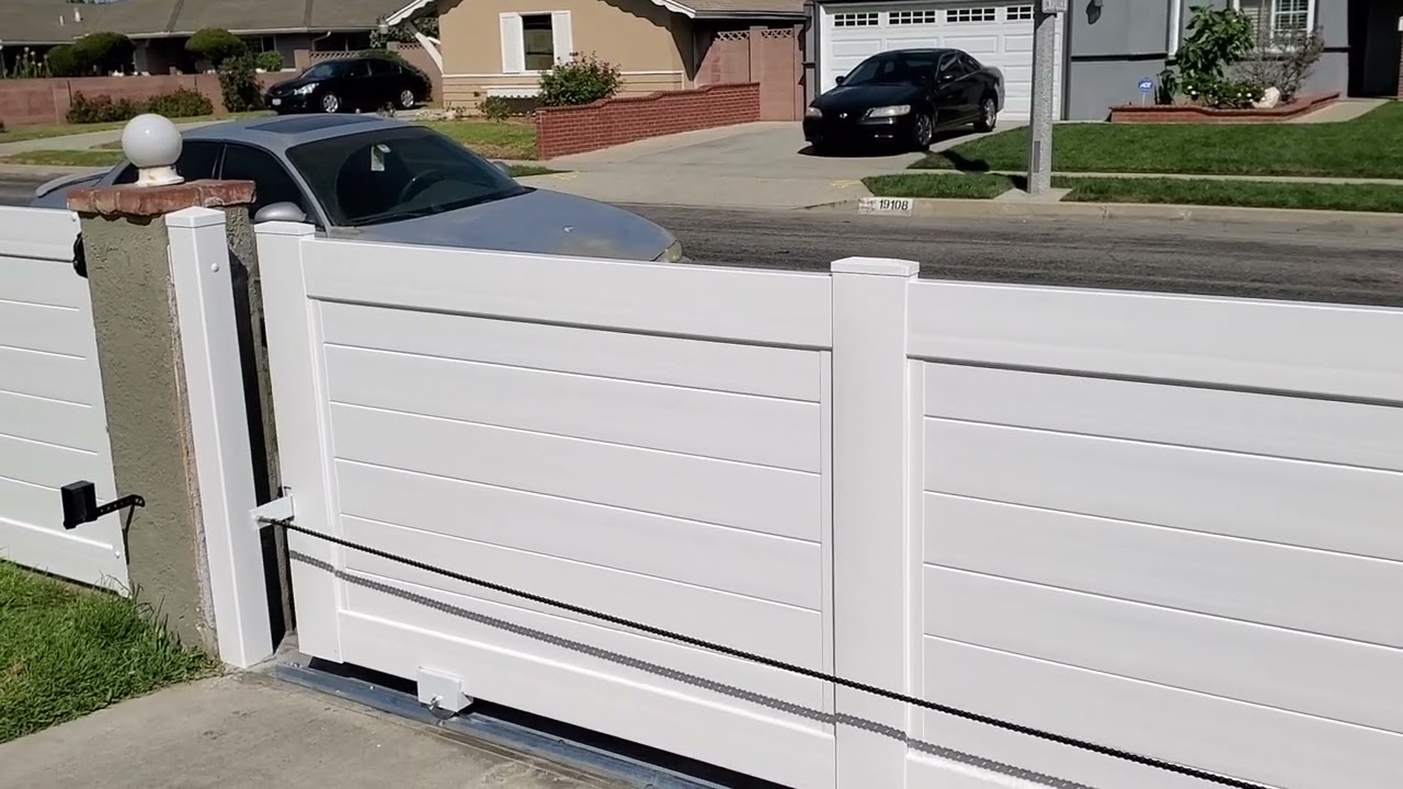 White vinyl rolling gate installation with special setback motor design